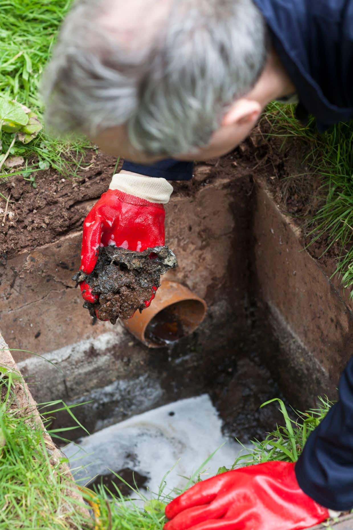 A person holding a dirt pile in a hole.